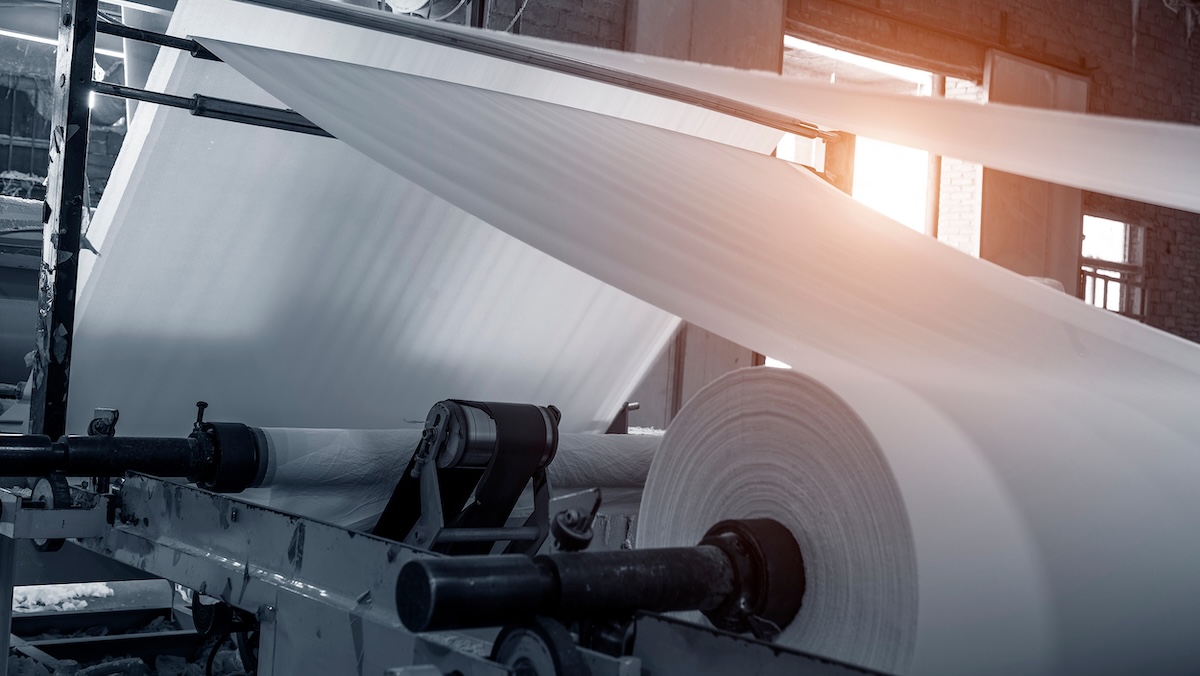 Large rolls of paper moving through an industrial mill, representing a Pacific Northwest paper producer using Regnor TT’s managed transportation.